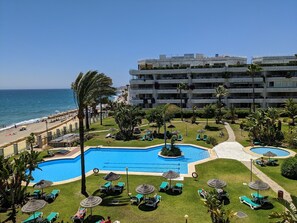 A resort with a large swimming pool, a beach, and a multi-story building with balconies. - Coral Beach Aparthotel (Marbella)