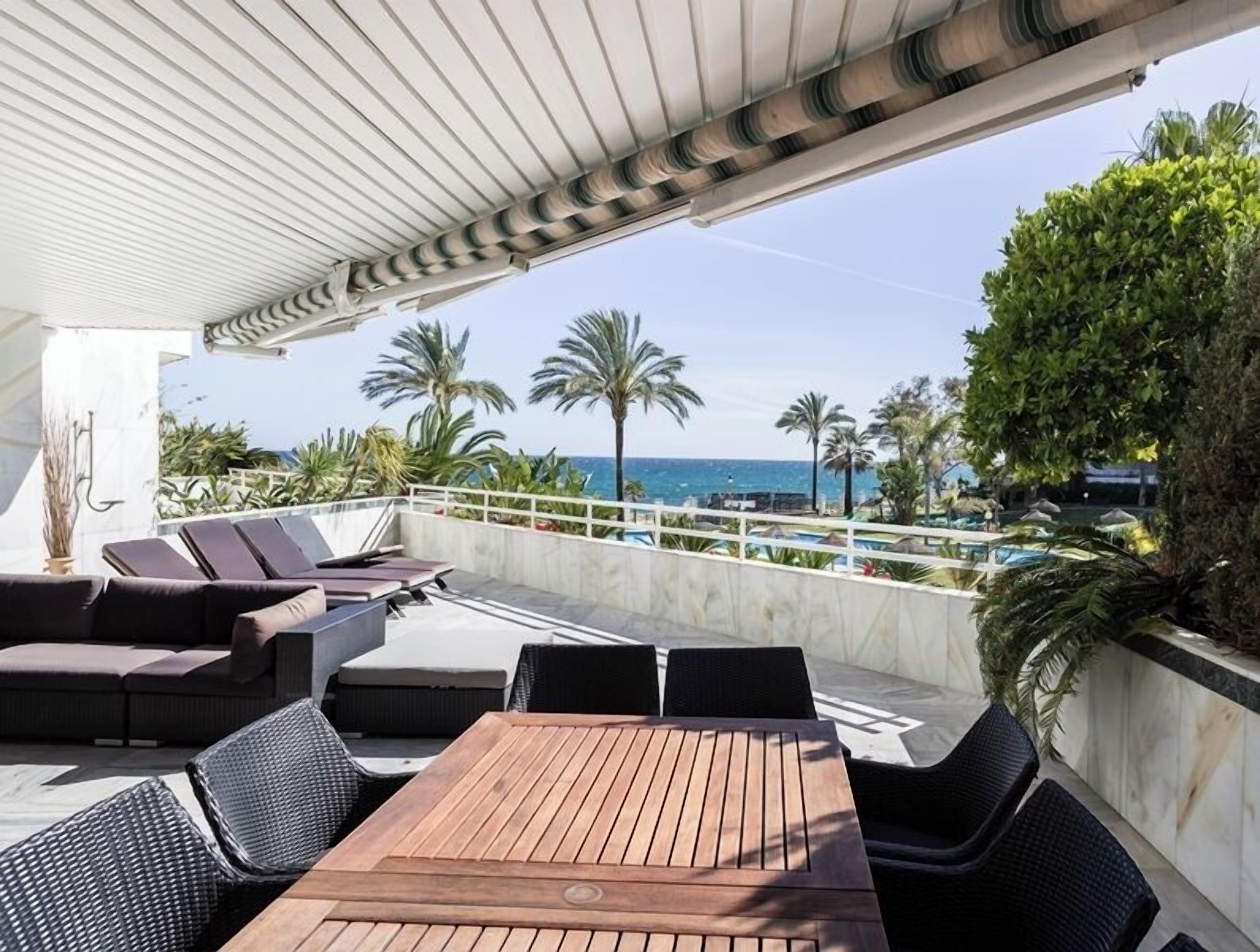 A rooftop terrace with outdoor seating, a pool, and a view of the sea.