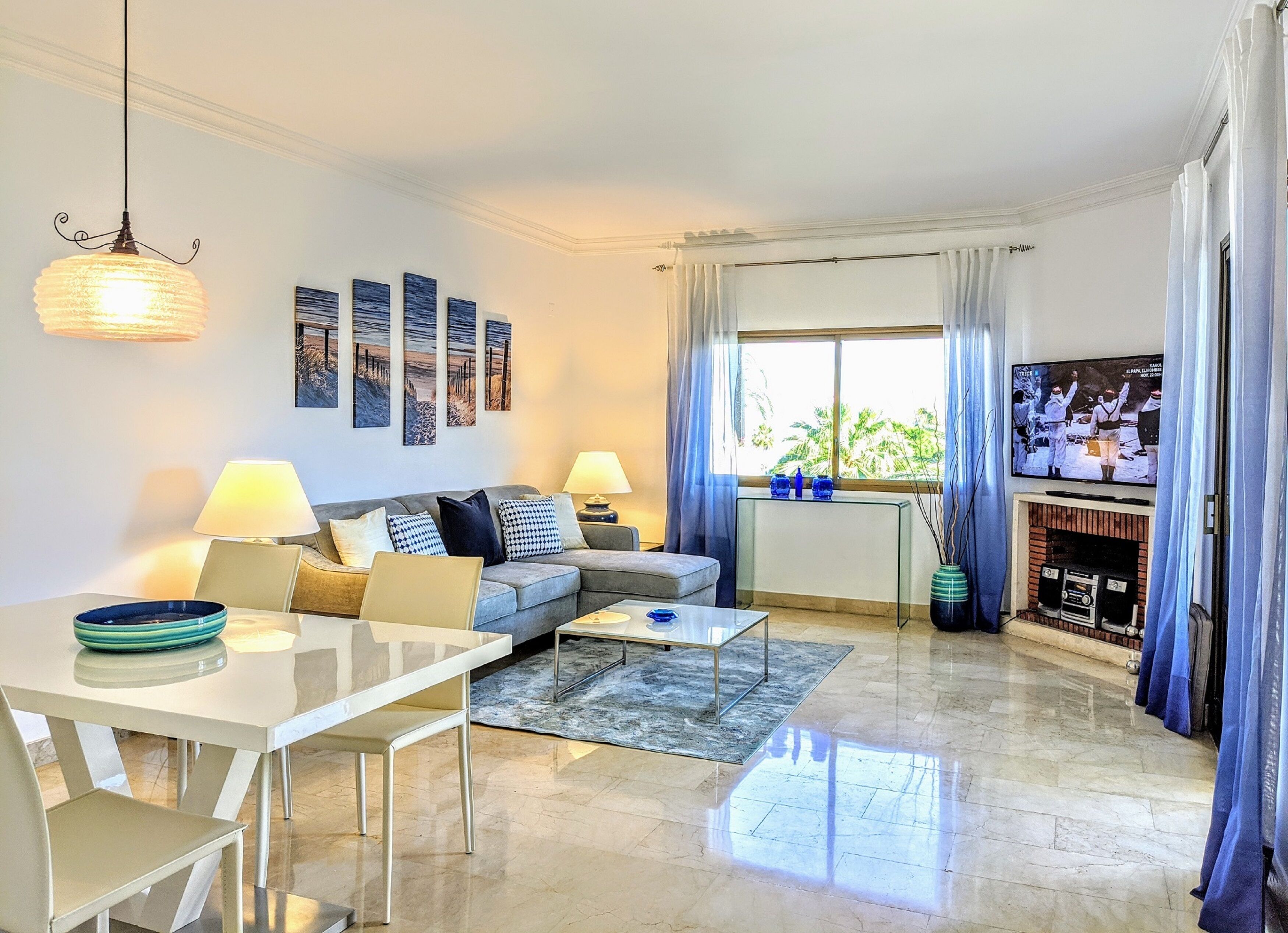A modern living room with a sofa, dining table, and TV.