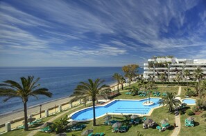 Un complejo turístico con piscina, playa y vista al océano.