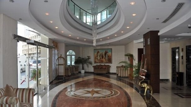 A spacious lobby with a central circular design, a chandelier, and a large painting on the wall. - Musherib Hotel (Doha)