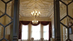A room with a geometric ceiling design, a chandelier, two chairs, and a patterned rug. - HHK Hotel (Istanbul)