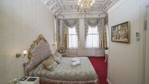 A luxurious bedroom with a large bed, ornate headboard, and a chandelier. - HHK Hotel (Istanbul)
