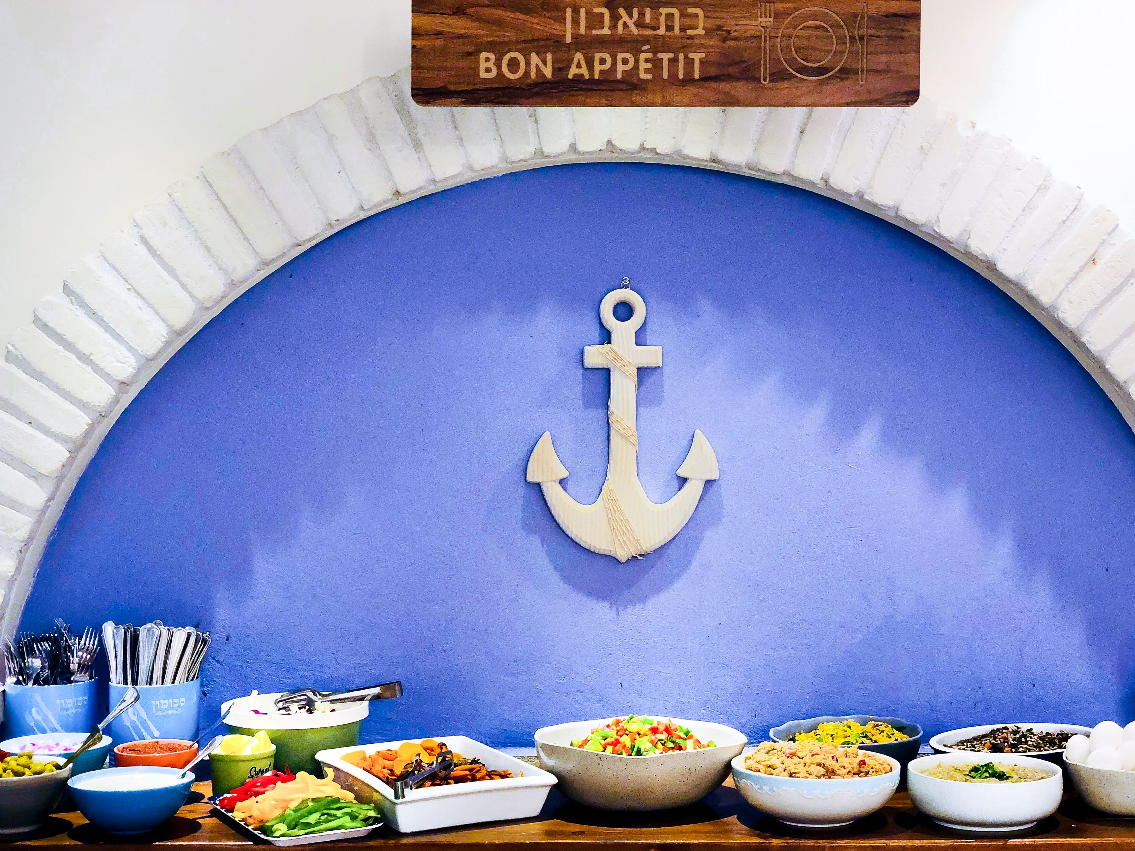 A buffet setup with various dishes and utensils.