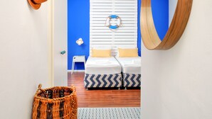 A bedroom with a bed, a blue wall, a wooden headboard, and a woven basket.