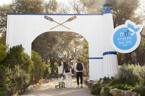 A white archway with crossed paddles and a sign for a travel hotel.
