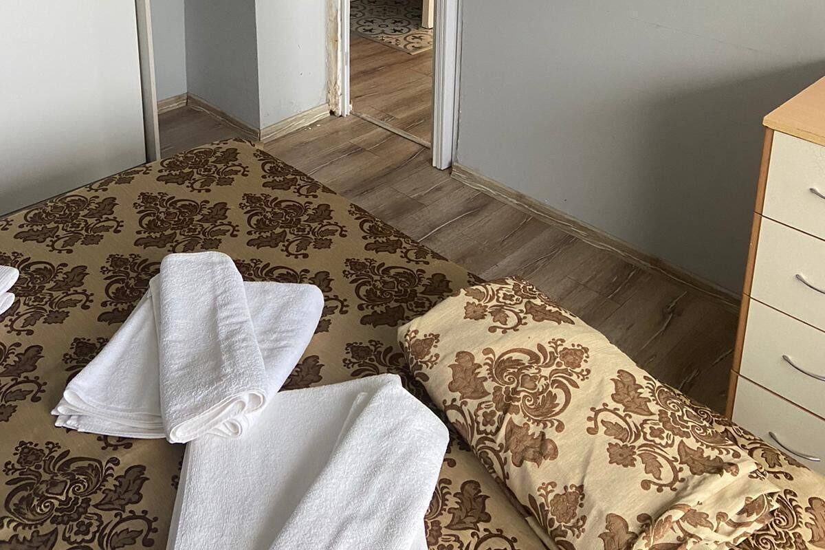 A hotel room with a bed, a TV mounted on the wall, and a door leading to a bathroom.