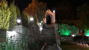 A stone pathway leading to a building with a dome and arches, surrounded by greenery and stone walls. - Ministar Hotel (Bodrum)
