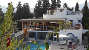 A hotel with a pool area, outdoor seating, and a view of the mountains. - Ministar Hotel (Bodrum)