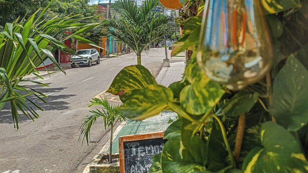 Vista de la calle con un letrero de 'Mar Praia' y una pizarra con la palabra 'TEXAS' escrita.