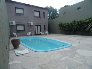 Una piscina al aire libre, sombrillas