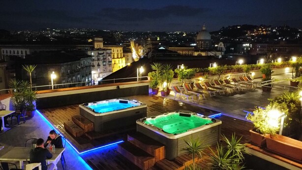 A rooftop terrace with two hot tubs, outdoor seating, and potted plants. - Sweet Sleep (Naples)