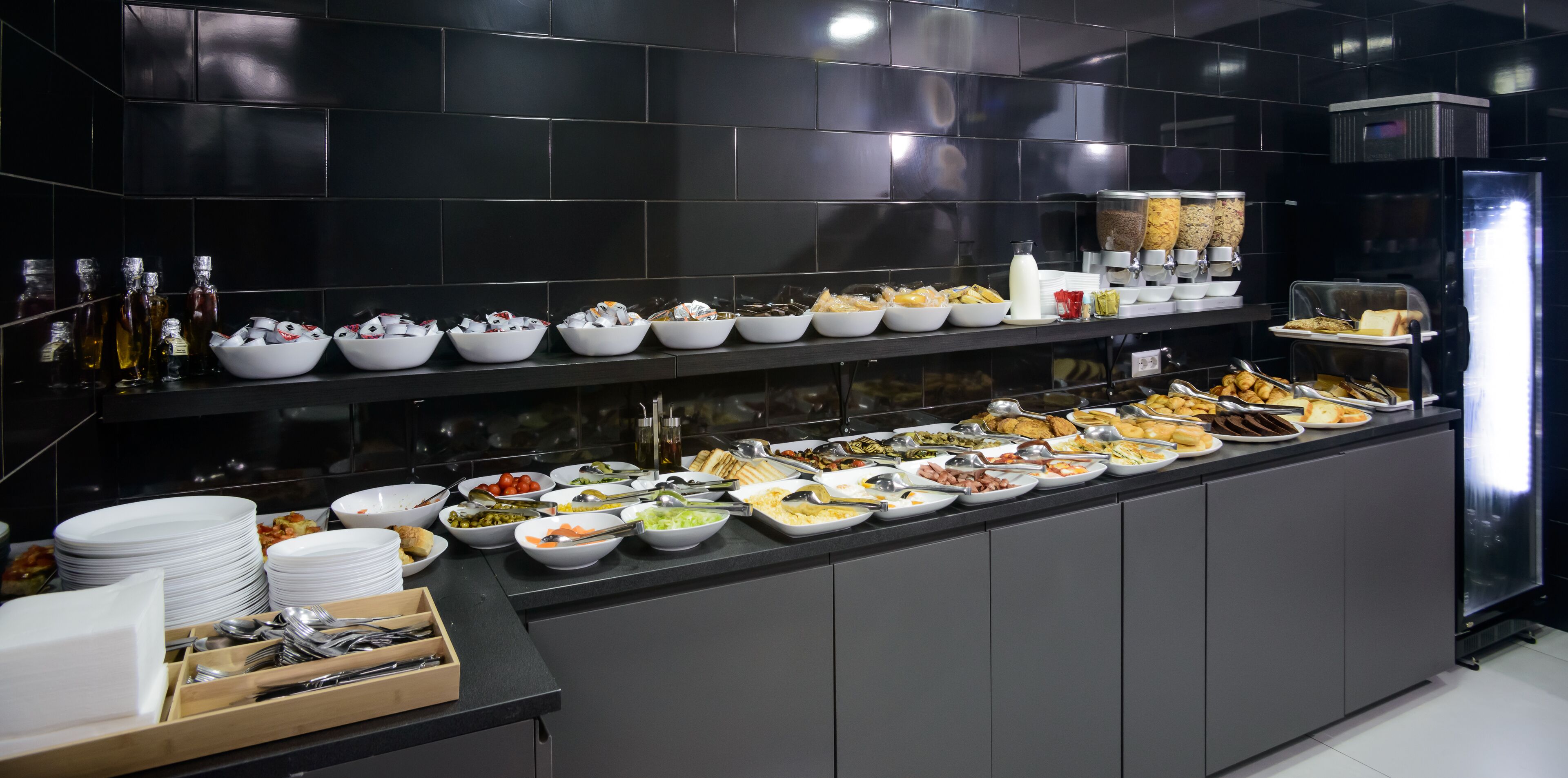 A buffet setup with various food items and condiments.
