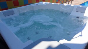 Un jacuzzi con una pared de azulejos al fondo.