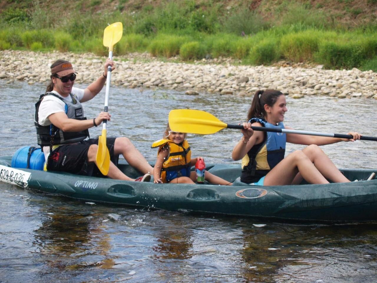 Un groupe de personnes dans un kayak vert sur une rivière.