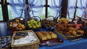 Una mesa con cestas de manzanas, kiwis, plátanos y pasteles.