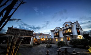 Un patio con edificios de piedra, mobiliario exterior y cielo despejado.