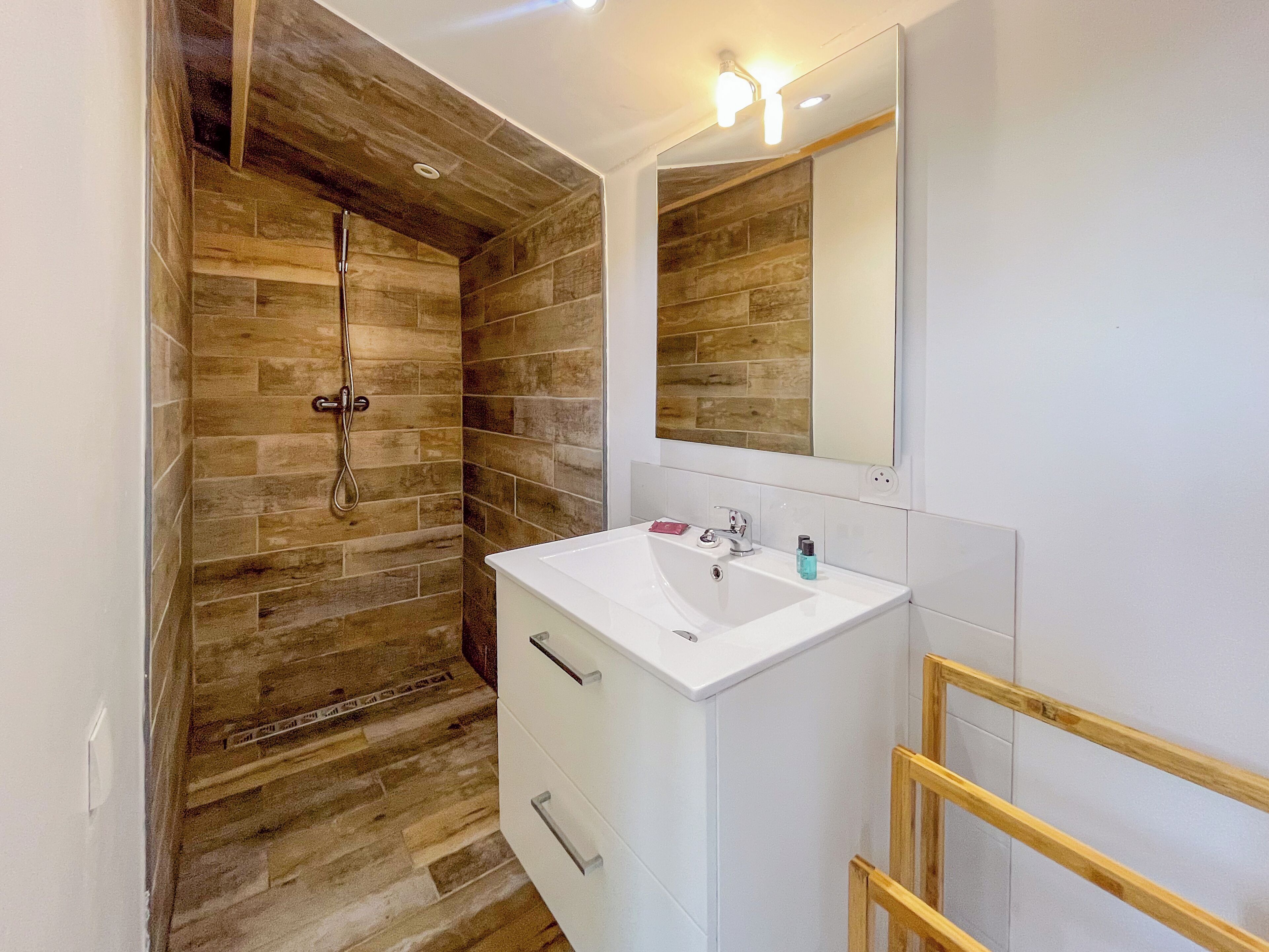 A bathroom with a shower, a sink, and a mirror.