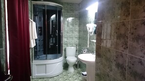 A bathroom with a shower, toilet, and sink.