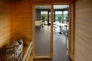 A wooden interior with a view to an outdoor balcony area. - GMP Clubhotel Apartments (Otepaa)
