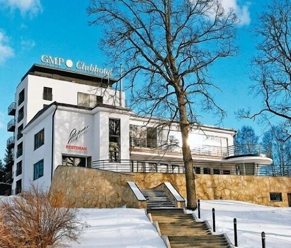 A modern hotel with a sign reading "CMP Choboty" and "Restoran" indicating a restaurant on the ground floor. - GMP Clubhotel Apartments (Otepaa)