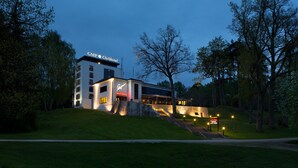 A modern hotel with a restaurant, a well-lit entrance, and a staircase leading up to the building. - GMP Clubhotel Apartments (Otepaa)