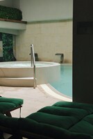 Una piscina techada, sillones reclinables de piscina