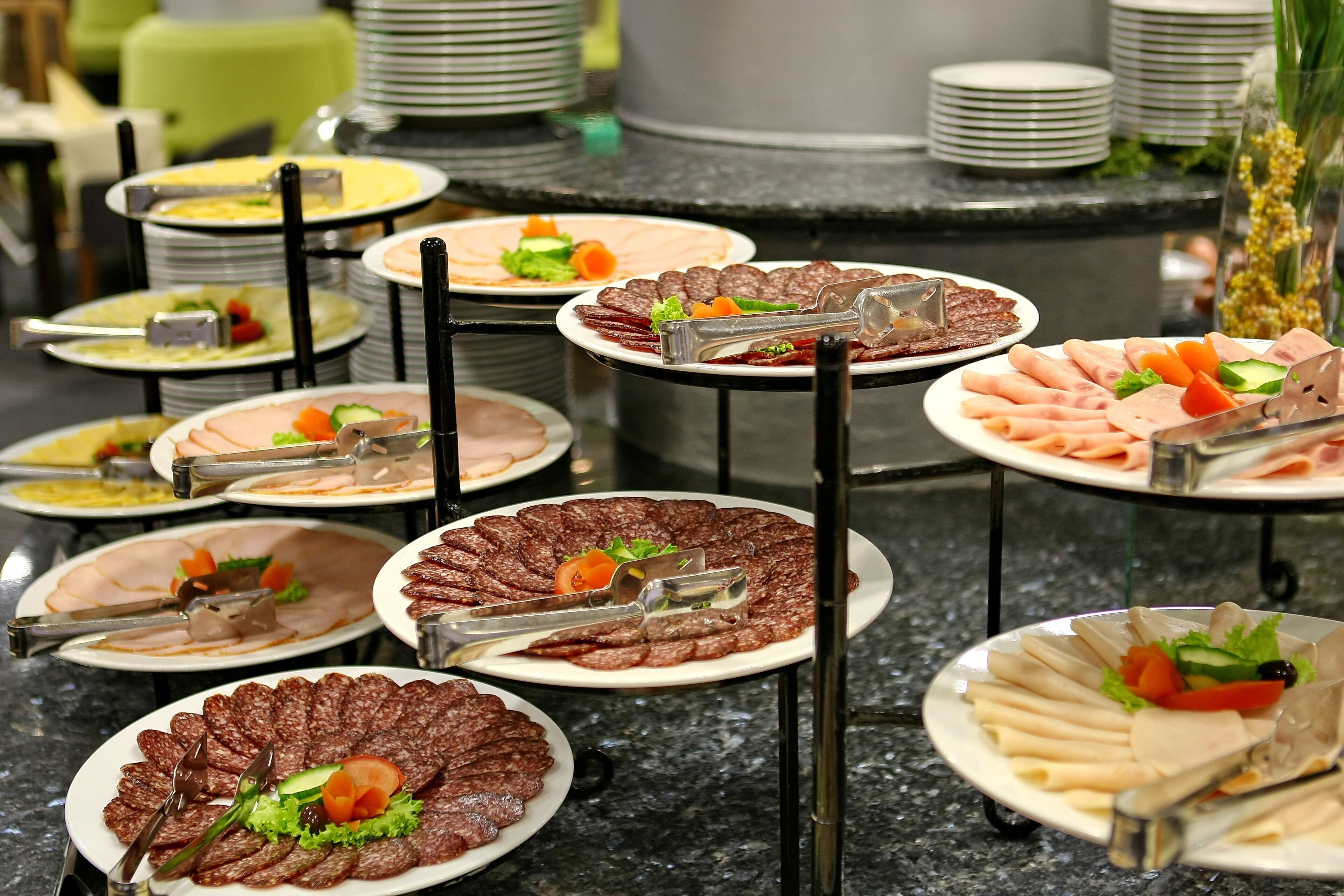 A buffet with various food items including sliced meats, vegetables, and salads.