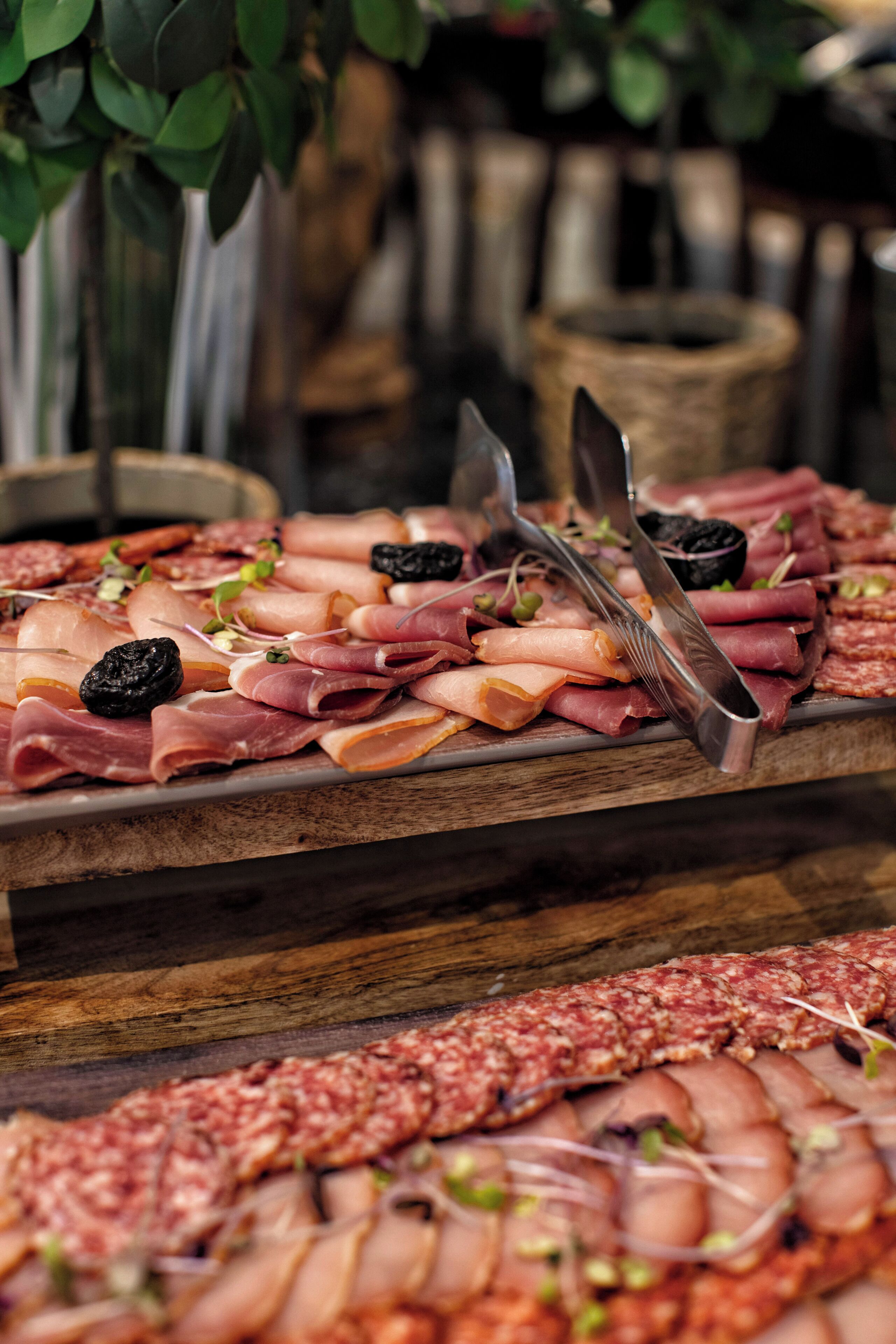 A charcuterie board with various meats and garnishes.