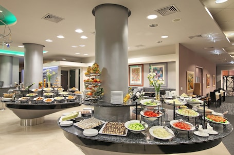 A buffet setup with various food items and a central decorative column.