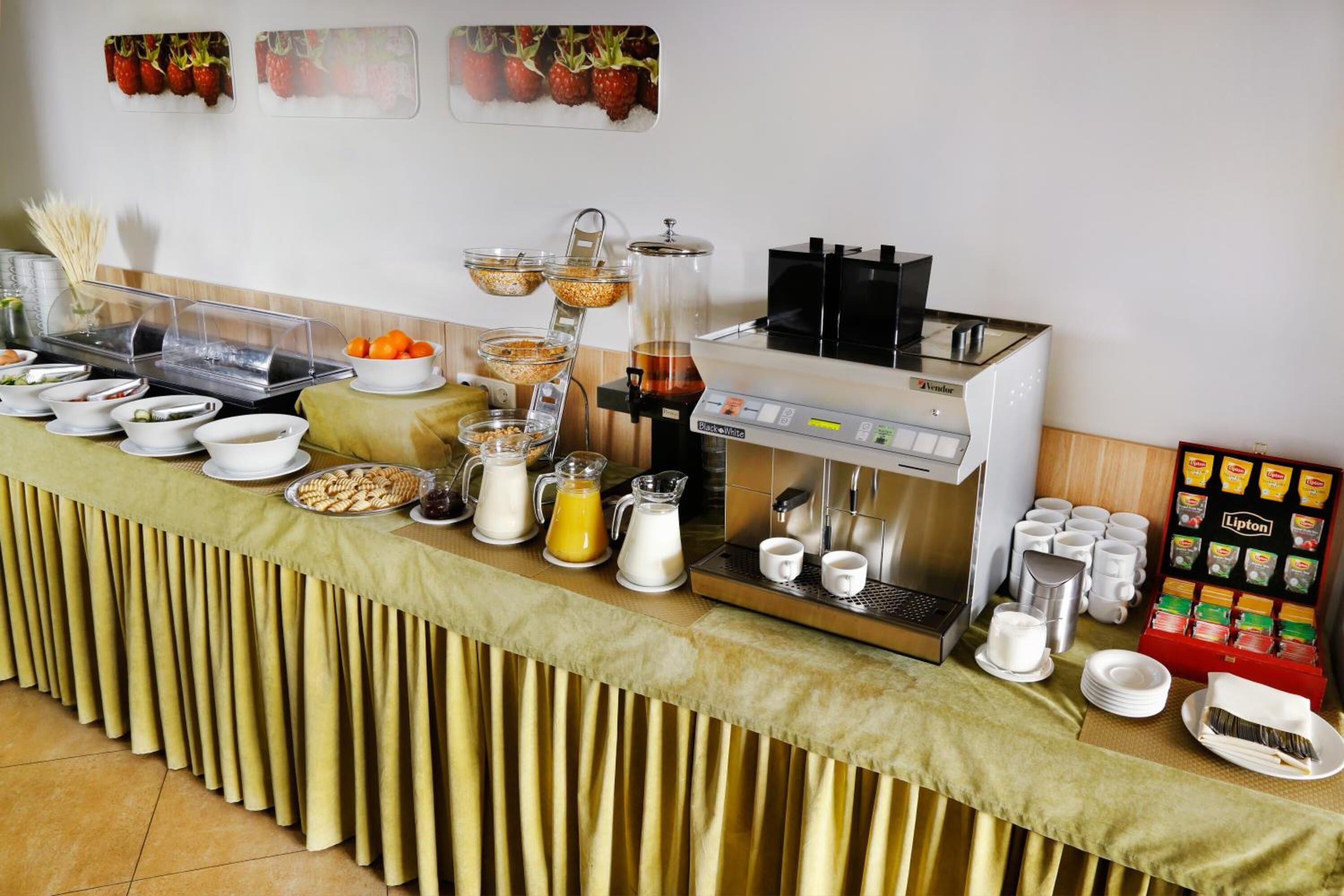 Een buffetopstelling met diverse gerechten, een koffiemachine en een servetdispenser.