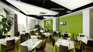 A conference room with multiple tables set for dining, equipped with chairs and table settings.