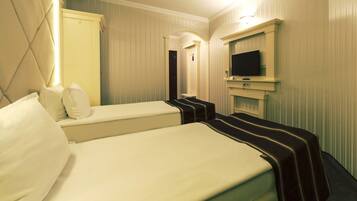 A hotel room with two beds, a TV, and a mirror.