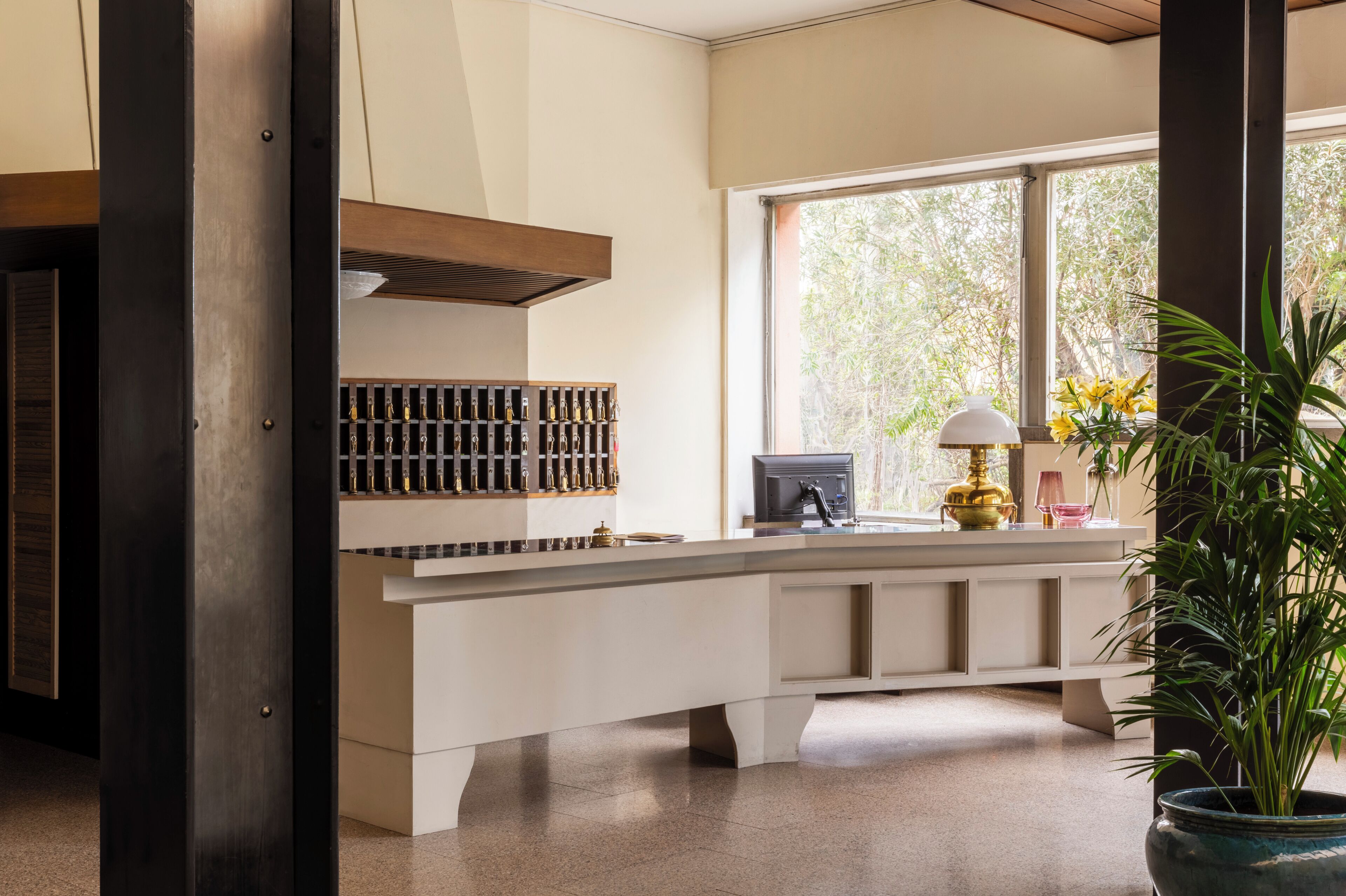 A modern kitchen with a central island, a built-in wine rack, and a large window with a view of greenery.