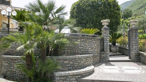 Un camino de piedra con palmeras y un diseño circular decorativo en el suelo.
