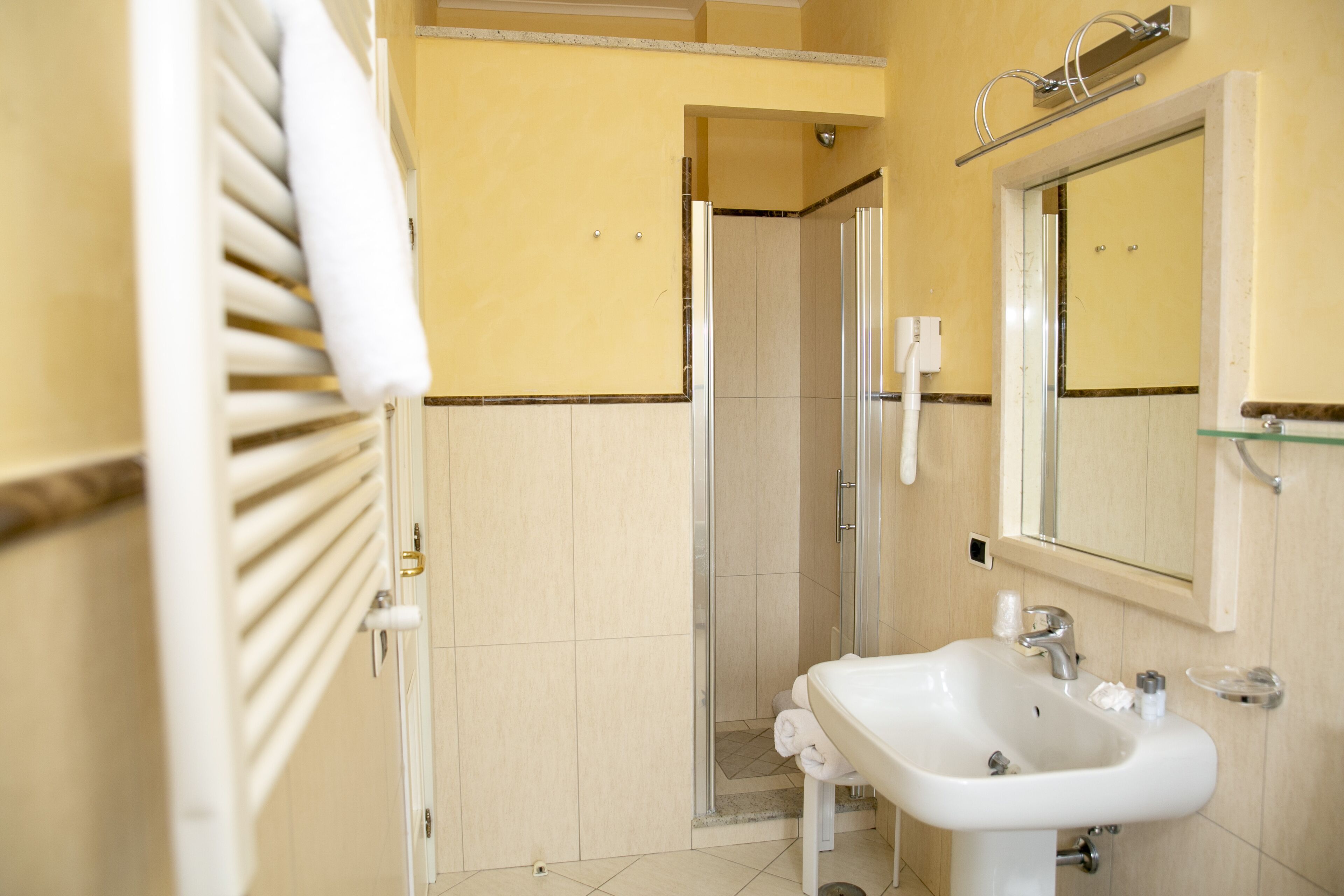 Ein Badezimmer mit Dusche, Waschbecken und Spiegel.