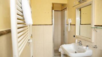 Ein Badezimmer mit Dusche, Waschbecken und Spiegel.