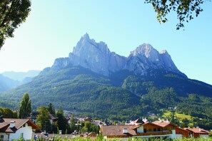 Un village de montagne aux maisons traditionnelles, avec un sommet imposant qui se dresse à l’arrière-plan.