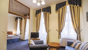 Ein Hotelzimmer mit einem Bett, zwei Sofas, einem Fernseher und einem kleinen Tisch.
