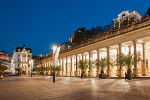 Un bâtiment imposant et illuminé, doté d’une série de colonnes et d’une vaste cour intérieure.