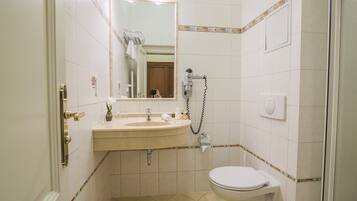 A small bathroom with a sink, mirror, and toilet.