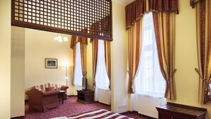 Ein Hotelzimmer mit Bett, Sofa, Schreibtisch und Kommode.