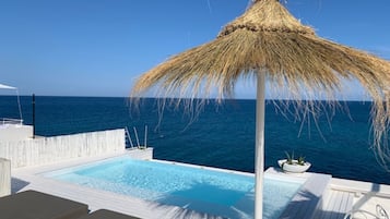 Een buitenzwembad, parasols voor strand/zwembad