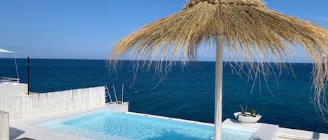 Piscine extérieure, parasols de plage, chaises longues