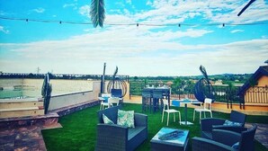 A rooftop terrace with outdoor furniture, a pool, and a view of the landscape. - Hotel La Cartiera (Vignola)