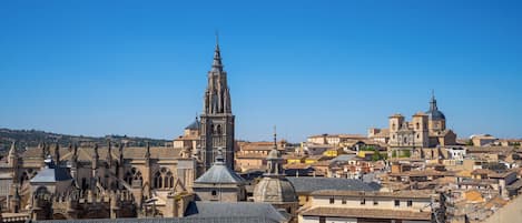 A historic cityscape with prominent Gothic architecture, including a tall cathedral and a smaller church with a dome.