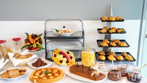 A buffet table with various food items including pastries, fruits, and desserts. - Panoramic Sunset (Kefalonia)