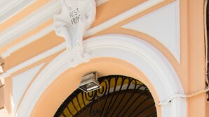 An entrance with a decorative archway, a door labeled '13', and a small sign above the door. - Hotel Indipendenza (Rome)