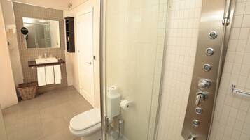 Un baño con inodoro, lavamanos y ducha.