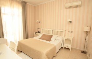 Relax in comfort with a large bed, bedside table, and air conditioning unit.